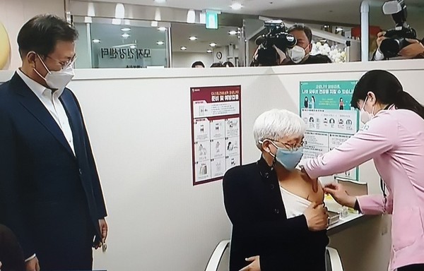 문재인 대통령이 마포구 보건소에서  코로나19 백신 첫 접종자를 지켜 보고 있다 [사진=TV화면 촬영 캡쳐]