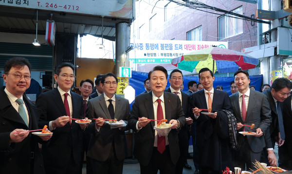 윤석열 대통령이 6일 부산 중구 깡통시장에서 재계 총수들과 함께 떡볶이, 튀김 등을 맛보고 있다.(사진=대통령실)