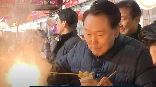 윤석열대통령이 25일 의정부 전통시장을 방문하여 상인들과 함께 어묵을 먹으면서 생생한 현장의 이야기를 경청했다[사진=티비화면 촬영 캡쳐]