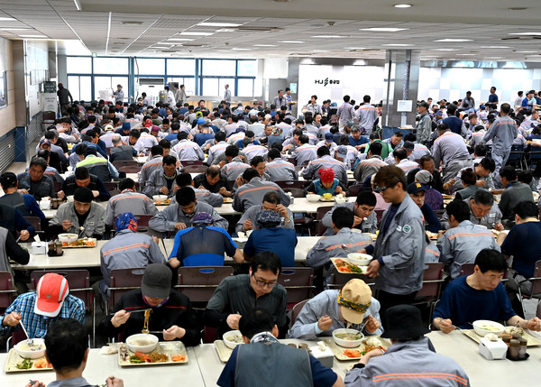 (사진=HJ중공업 근로자들이 삼계탕으로 식사를 하고 있다.)