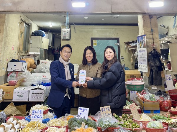 (사진=부산항만공사 엄기용 ESG경영실장이 BPA희망곳간 1호점(동삼종합사회복지관)에 정기적으로 채소를 기부하고 있는 부산 영도구 남항시장 내 ‘오씨 채소’가게에  현판을 전달하고 있다.)