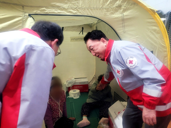 대한적십자사 김철수 회장(오른쪽)이 23일 경남 산청 산불 이재민 대피소인 단성중학교를 방문해 임시구호텐트에 있는 이재민들을 위로하고 있다.(사진=대한적십자사)