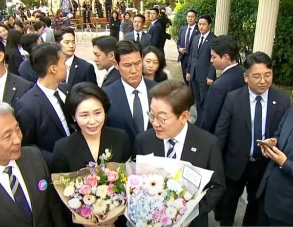 4일 이재명 대통령 부부가 주민들로 부터 대통령 당선 축하 꽃다발을 받고 있다 [사진=티비화면 촬영]